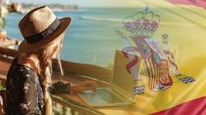Brown cowboy hat and leather jacket against Spanish flag with coastal background